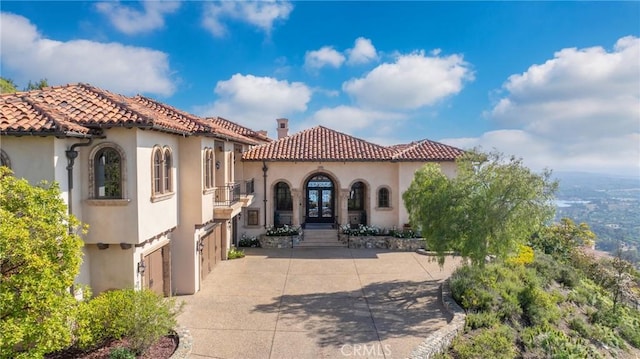 7811 Camino De Arriba, Rancho Santa Fe, CA 92067 - view of front of house featuring french doors, stucco siding, a balcony, a garage, and a chimney