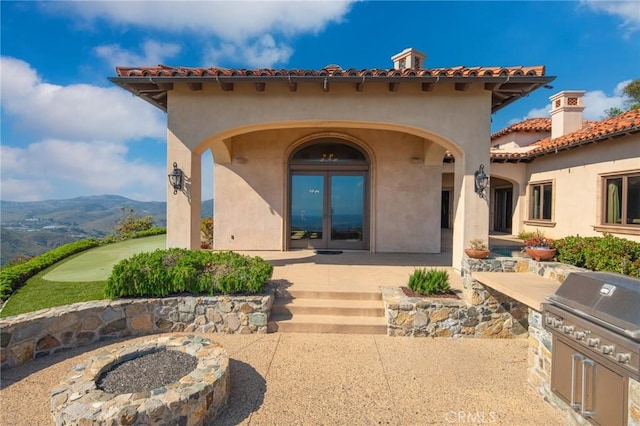 7811 Camino De Arriba, Rancho Santa Fe, CA 92067 - property entrance featuring stucco siding, a tiled roof, a mountain view, and an outdoor kitchen