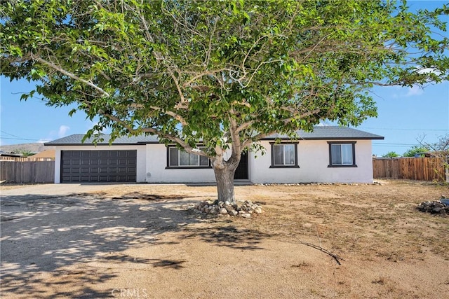 22047 Wren St, Apple Valley, CA 92308 - view of front facade featuring fence, driveway, a garage, and stucco siding