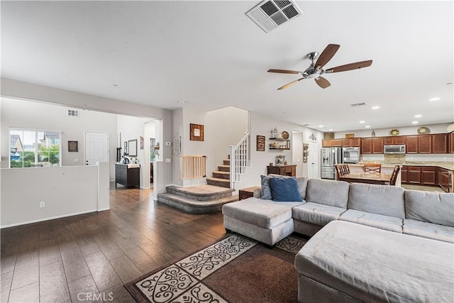 living room featuring a ceiling fan, dark wood-style floors, recessed lighting, and stairs