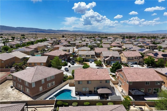 aerial perspective of suburban area with a mountainous background and a pool