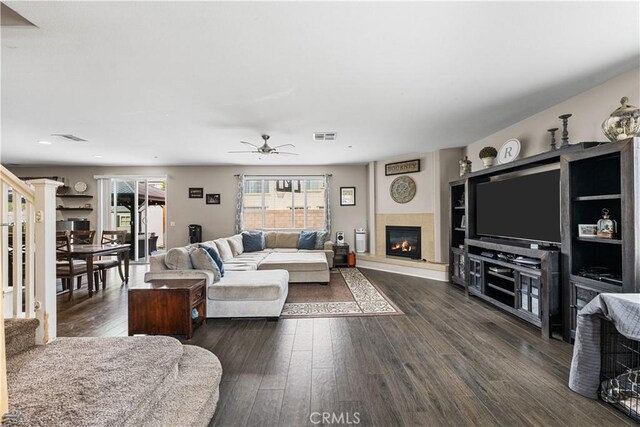 living room with ceiling fan, a glass covered fireplace, dark wood-style flooring, recessed lighting, and stairs