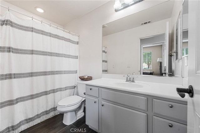bathroom with vanity, toilet, and wood finished floors