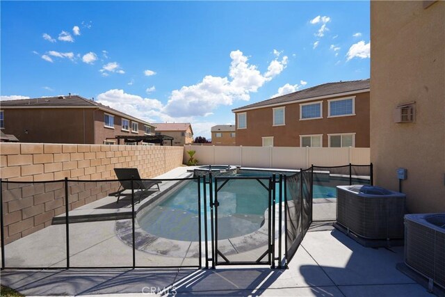 view of pool featuring central air condition unit, a fenced backyard, a pool with connected hot tub, and a patio area