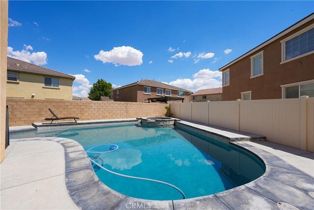 view of pool with a fenced backyard and a pool with connected hot tub