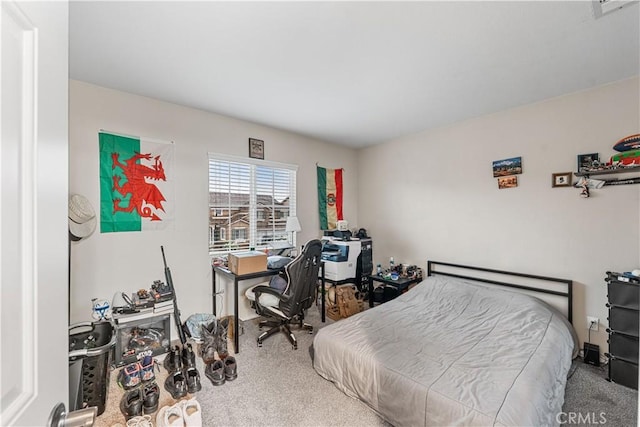 carpeted bedroom featuring an office area