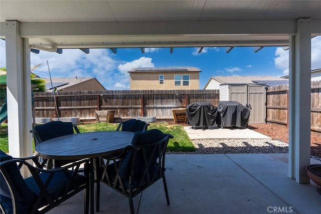 627 Suzanne Dr, Merced, CA 95348 - view of patio featuring outdoor dining area, a fenced backyard, and a grill