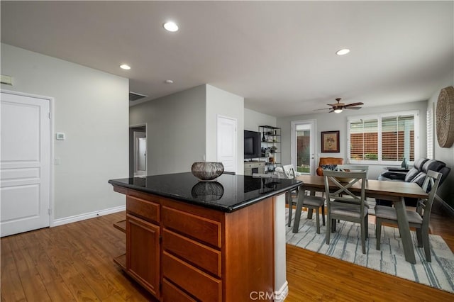 39453 Cardiff Ave, Murrieta, CA 92563 - kitchen featuring dark wood-style floors, a kitchen island, ceiling fan, dark stone counters, and recessed lighting