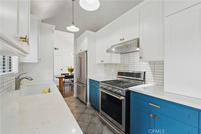 kitchen with under cabinet range hood, high end appliances, blue cabinetry, a sink, and decorative backsplash