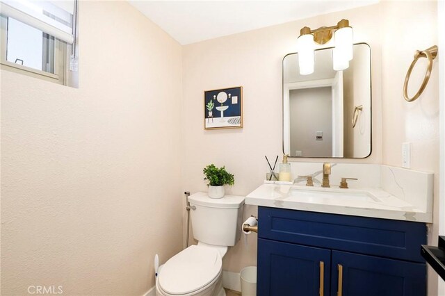 half bathroom featuring vanity and toilet
