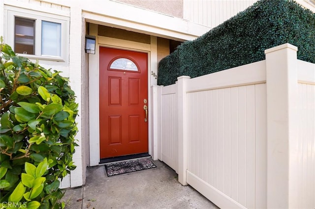 view of exterior entry featuring fence