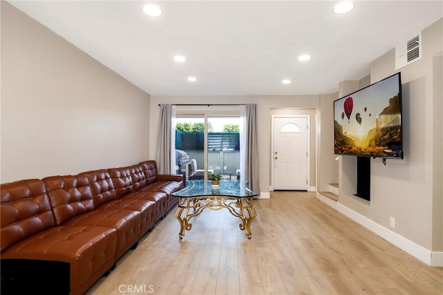 living area featuring light wood-style flooring, baseboards, and recessed lighting