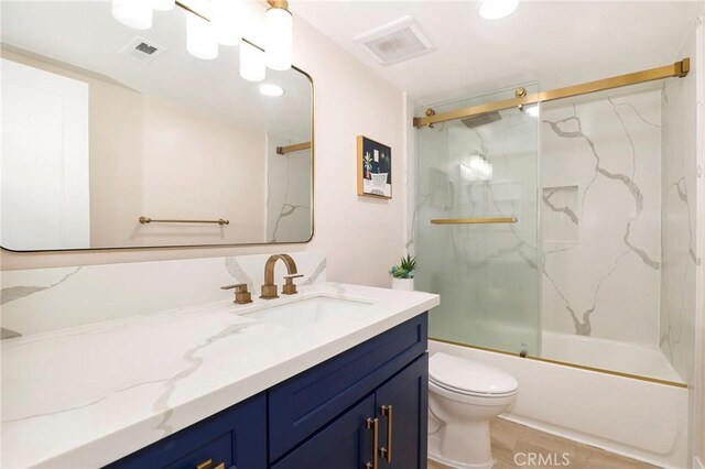 full bath featuring toilet, vanity, enclosed tub / shower combo, and recessed lighting