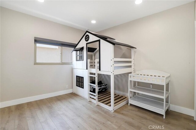 bedroom featuring wood finished floors, baseboards, and recessed lighting