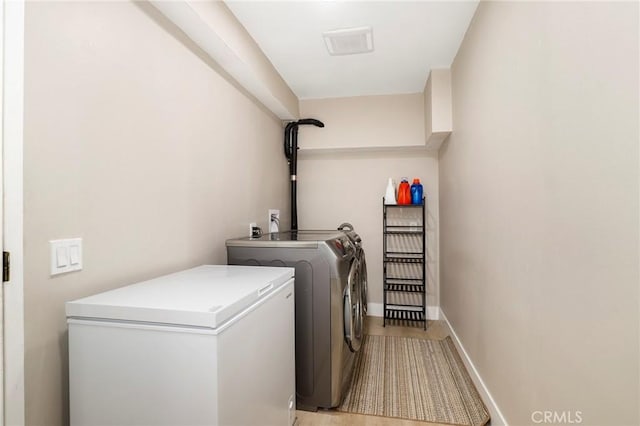 laundry room featuring independent washer and dryer and baseboards