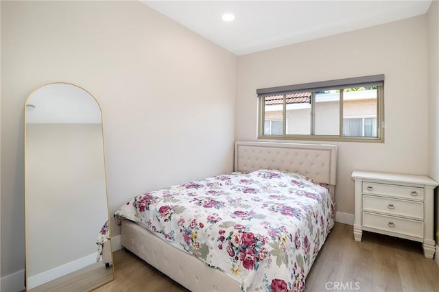 bedroom with wood finished floors, baseboards, and recessed lighting