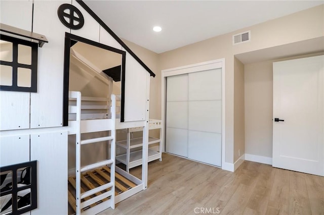 corridor featuring light wood finished floors, baseboards, and recessed lighting