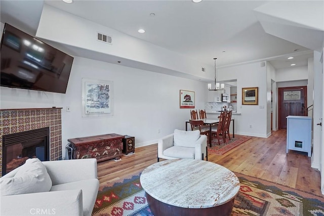 14702 Magnolia Blvd Unit 104, Sherman Oaks, CA 91403 - living room with wood finished floors, baseboards, a tile fireplace, recessed lighting, and a chandelier
