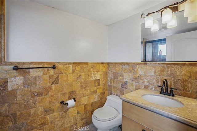 14702 Magnolia Blvd Unit 104, Sherman Oaks, CA 91403 - bathroom with tile walls, toilet, vanity, and wainscoting