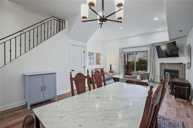 14702 Magnolia Blvd Unit 104, Sherman Oaks, CA 91403 - dining space featuring a chandelier, stairs, wood finished floors, a tiled fireplace, and baseboards