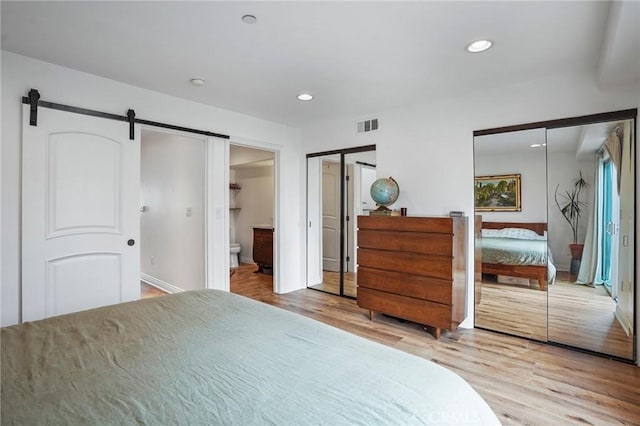 14702 Magnolia Blvd Unit 104, Sherman Oaks, CA 91403 - bedroom featuring wood finished floors, multiple closets, a barn door, baseboards, and recessed lighting