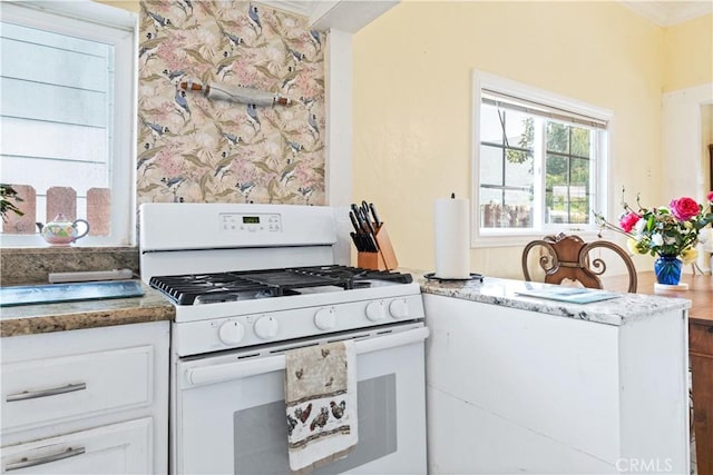 171 Brook St, San Luis Obispo, CA 93401 - kitchen with white gas range, white cabinetry, stone countertops, and crown molding