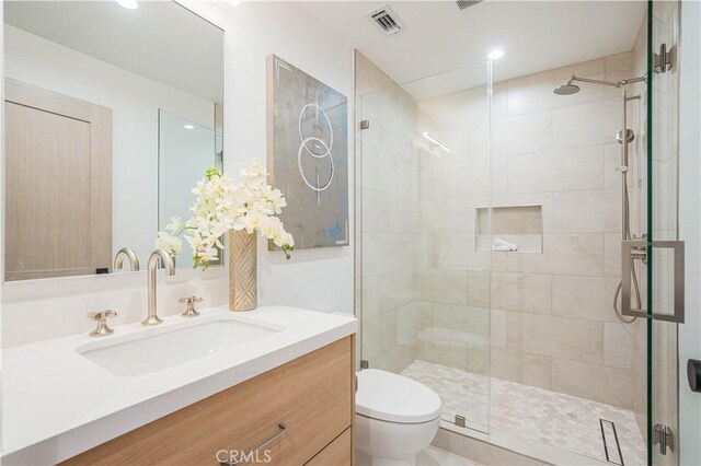 full bath featuring toilet, a shower stall, vanity, and recessed lighting