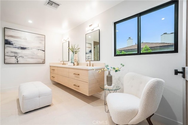 full bathroom featuring double vanity and baseboards