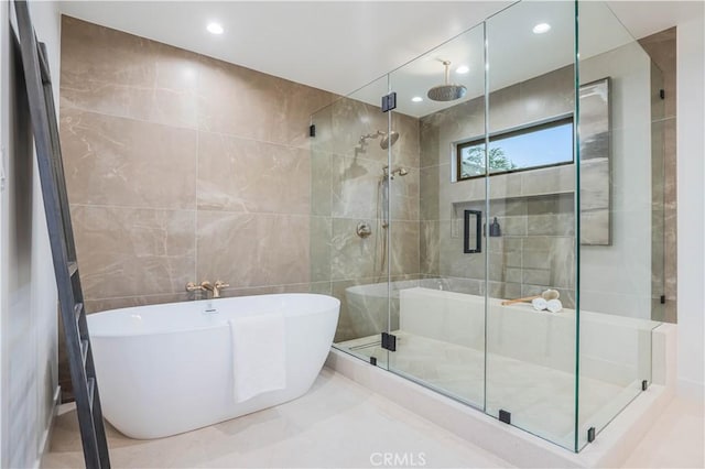 full bath with tile walls, a stall shower, a soaking tub, marble finish flooring, and recessed lighting