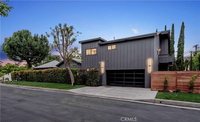 view of front facade featuring fence, driveway, and an attached garage