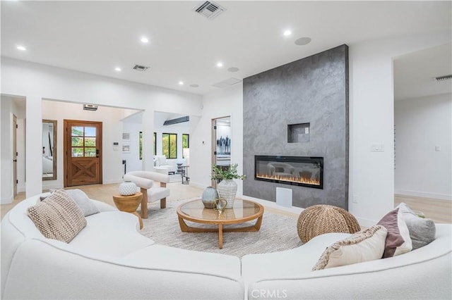 living room with recessed lighting, a fireplace, and baseboards