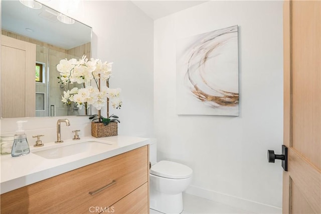 bathroom with a stall shower, toilet, vanity, and baseboards