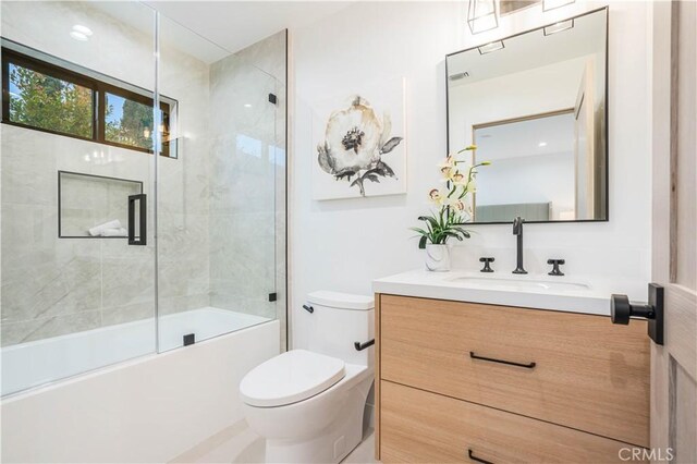 bathroom with toilet, vanity, and shower / bath combination with glass door