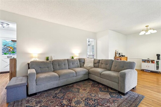 16133 Haldane St, Whittier, CA 90603 - living area with wood finished floors, a textured ceiling, and a chandelier