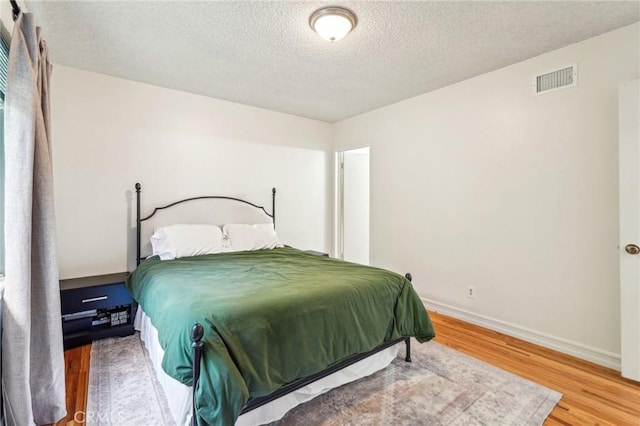 16133 Haldane St, Whittier, CA 90603 - bedroom featuring wood finished floors, a textured ceiling, and baseboards