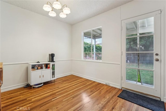 16133 Haldane St, Whittier, CA 90603 - playroom with a chandelier, wood finished floors, a textured ceiling, and baseboards