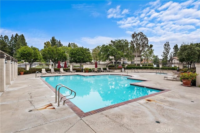 community pool featuring a patio area and fence