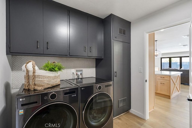 2506 E Roberta Dr, Orange, CA 92869 - laundry room with washing machine and clothes dryer, cabinet space, light wood-type flooring, and baseboards