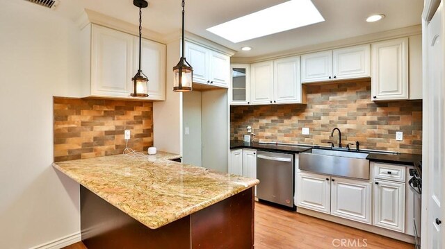 kitchen featuring dishwasher, a sink, a peninsula, decorative backsplash, and recessed lighting