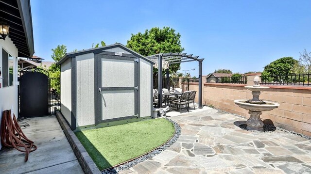 view of shed with a fenced backyard, a pergola, and outdoor dining area