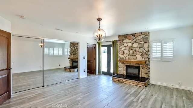 unfurnished living room featuring a fireplace, plenty of natural light, and wood finished floors