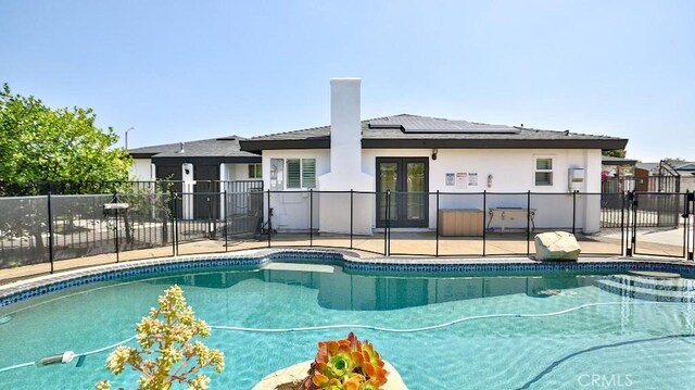 view of swimming pool featuring french doors, a patio, and fence