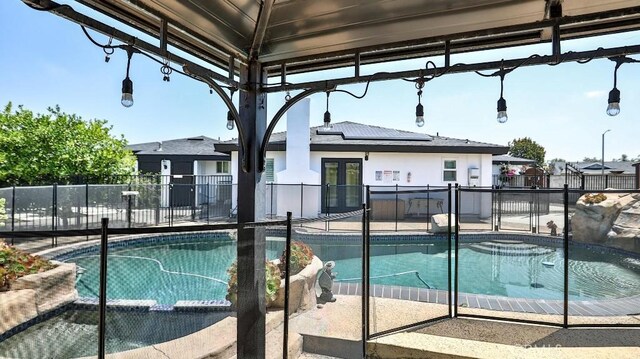 view of pool featuring french doors, a patio, and fence