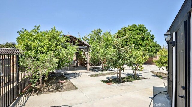 view of home's community with a patio area, a fenced backyard, and a gazebo