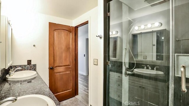 full bath with a stall shower and double vanity