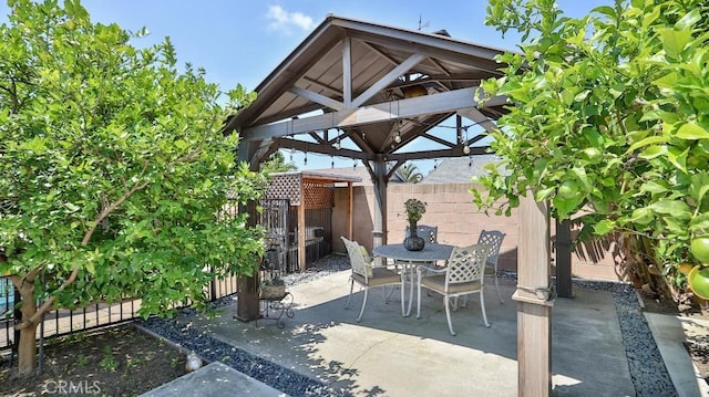 view of patio featuring a gazebo, fence, and outdoor dining area