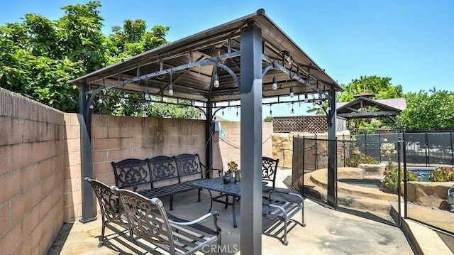 view of patio / terrace with a gazebo, a fenced backyard, and an outdoor hangout area