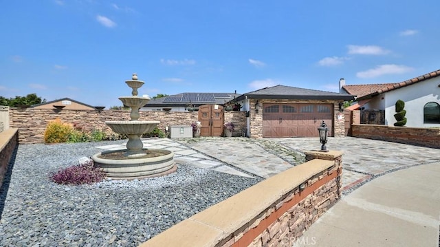 view of front of home with fence, concrete driveway, stone siding, and an attached garage