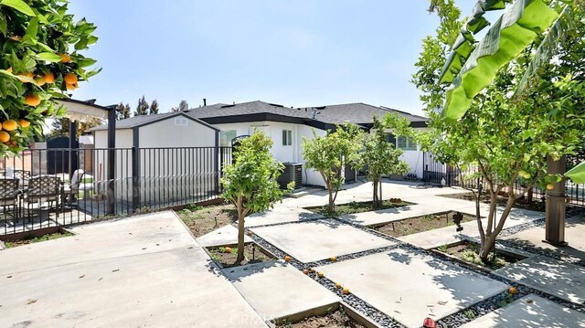 view of front of house featuring fence, a patio area, and cooling unit