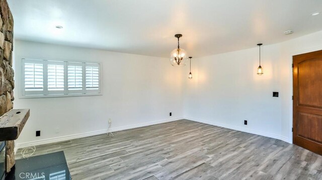 unfurnished dining area featuring wood finished floors and baseboards